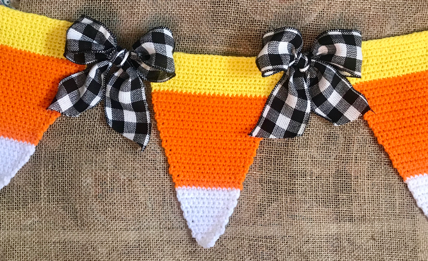 Up close photo showing stitch work and bows for this Crochet Candy Corn Bunting.